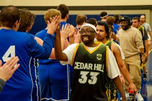 Basketball teams walk a line to high five their competitors after a game.