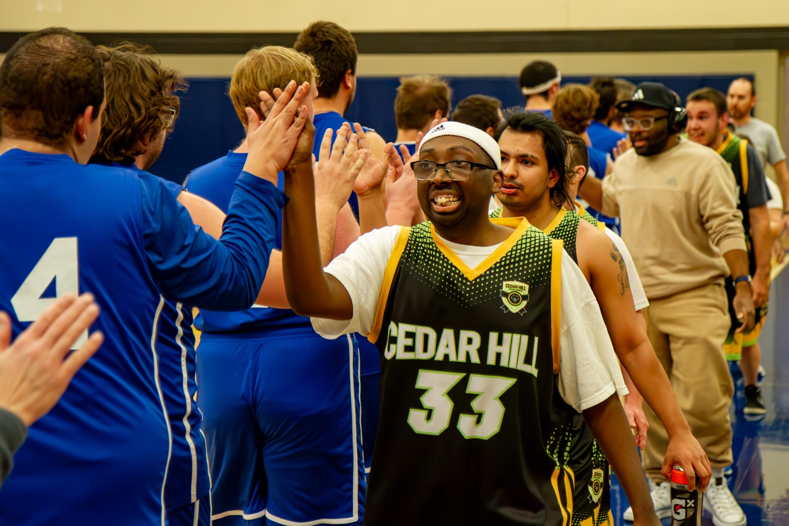 Basketball teams walk a line to high five their competitors after a game.